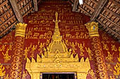 Luang Prabang, Laos - Wat Si Boun Huang, the main door is decorated with a gilded high reliefs in the shape of a stupa among stencilled gilded apsaras. 